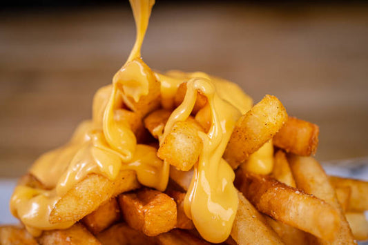 Golden crispy fries topped with creamy cheddar cheese sauce and green onions, perfect for a quick comfort food snack.